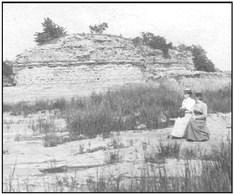 Victorian women sit with the original Roche de Boeuf rock.
