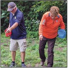 Park Commissioners Bill Cameron and Sandy Wiechman spread seeds they collected on a section of ground at Bradner Preserve.