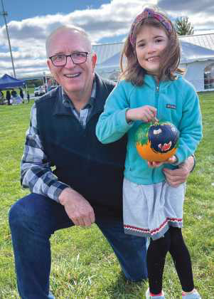 Lena Coulson, pictured with her grandfather and Perrysburg Rotarian Mark Weber, displays her painted pumpkin.