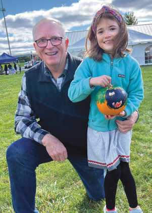 Lena Coulson, pictured with her grandfather and Perrysburg Rotarian Mark Weber, displays her painted pumpkin.