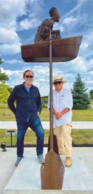 Jurors Terry Lesniewicz and Emanuel Enriquez standing under Best of Show sculpture, “I Went to See,” by J. Aaron Alderman.