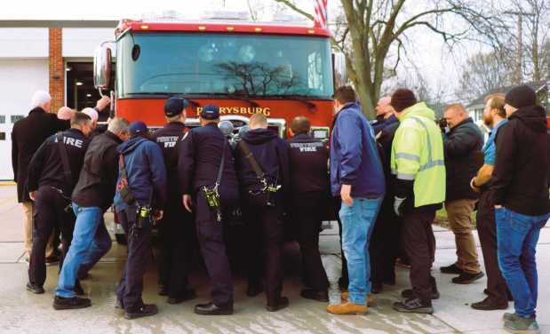 Firefighters push the fire engine into the station.