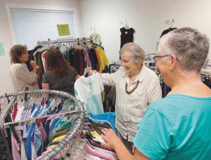 Volunteers arrange items at the Clothesline, a free clothing store offered through the Timothy’s Perrysburg Foundation.