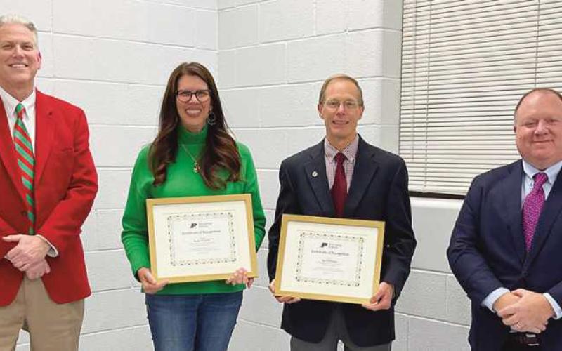 Departing members Kelly Ewbank and Ray Pohlman receive recognition from the board of education. From left are Superintendent Tom Hosler, Ms. Ewbank, Mr. Pohlman and board President Eric Benington.
