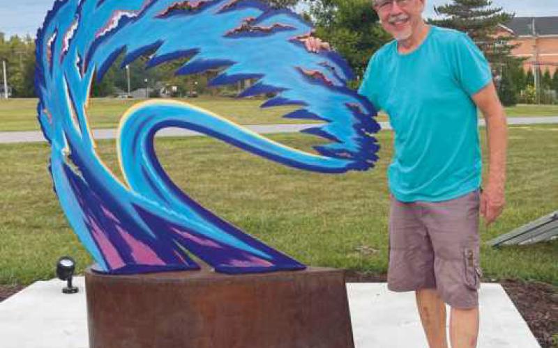 Artist Robert Garcia with his sculpture Burning Bush.