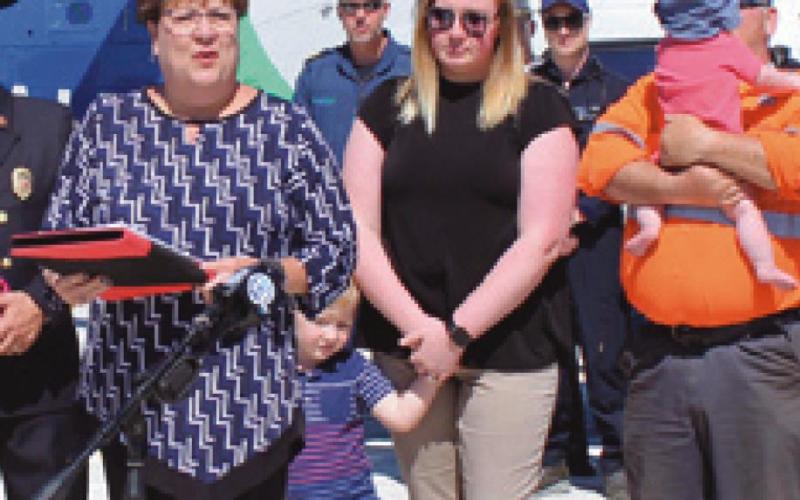 Left, Sandy Wiechman, Safe Communities coordinator, presents the Saved by the Belt award to Rachel Buehrer who was accompanied by her husband and children.