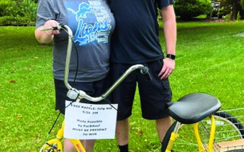 Bike raffle winner Katie Grant (left, pictured with her husband) was elated when her winning ticket number was read on July 6. The Perrysburg Slow Rollers are grateful for the donation of the 3-wheel bike by Par Bikes.