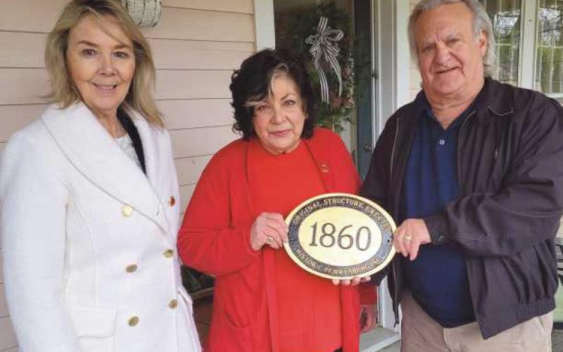 Diane Rogers, of the Guest House, 120/122 West Louisiana Avenue, recently received a historic marker from Historic Perrysburg Inc. Pictured are, from left: Joy Studer, Ms. Rogers and Dave Kleeberger. The home was built in 1860.