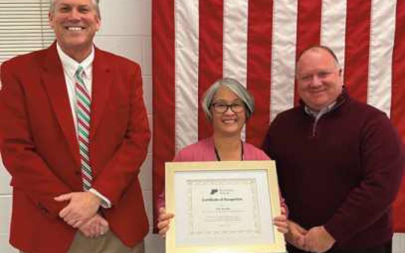 Lila Szozda receives her Certificate of Recognition from, left, Superintendent Tom Hosler, and right, Board of Education President Eric Benington on December 19.