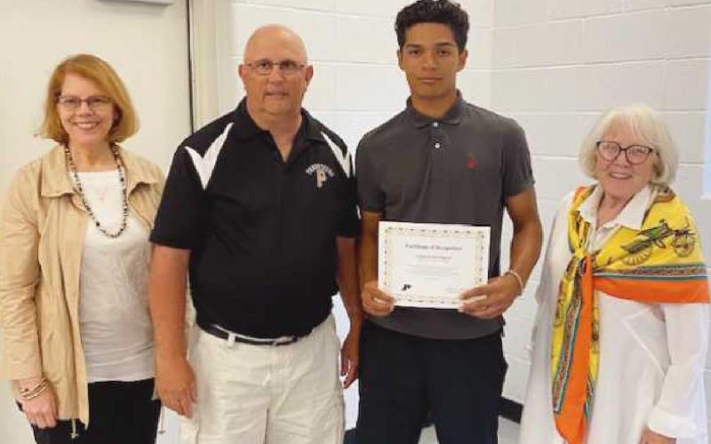 School board members Sue Larimer, left, and Gretchen Downs, right, with Dave Hall, head baseball coach, and Cameron Darrington, First Team All-State.
