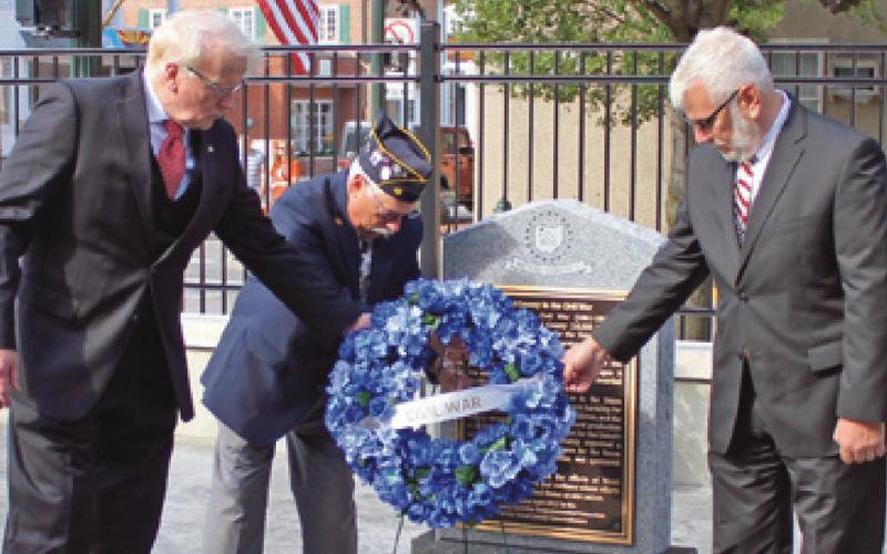 Commissioners Ted Bowlus, left, and Craig LaHote, right, place a wreath at the Civil War memorial.