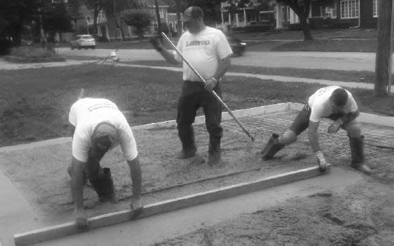 A work crew sets concrete upon which the cannons will be placed.