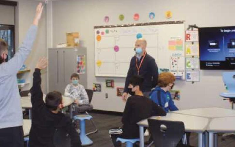 Top: Teacher Rebecca Bird with PHS seniors Sydney Toon, Katie Petrie, and Kyle Ohanian. Middle: Jim Toon shares his real estate expertise. Bottom: Dan Petrie asks for volunteers to illustrate a finance lesson.