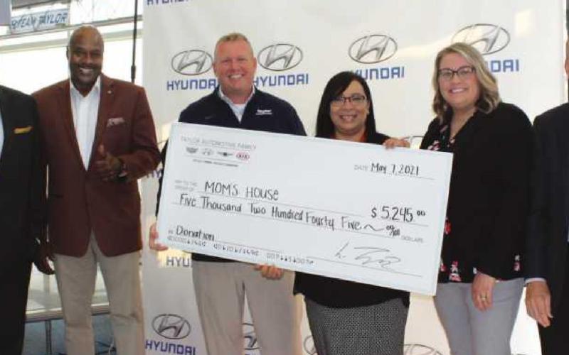 From left: Tom Cole, community outreach coordinator, and Terry Crosby, outreach community ambassador for Taylor Automotive; Steve Taylor, general manager; Christina Rodriguez, executive director, Julie Haas, program manager, and Mike Kruse, board president for Momʼs House.