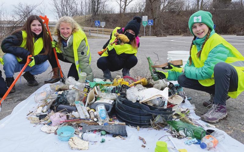 Quinn Rerucha, Courtney Sanders, Lanie Wood, and Julia Vickers with trash collected near Fort Meigs along the Maumee River shore.