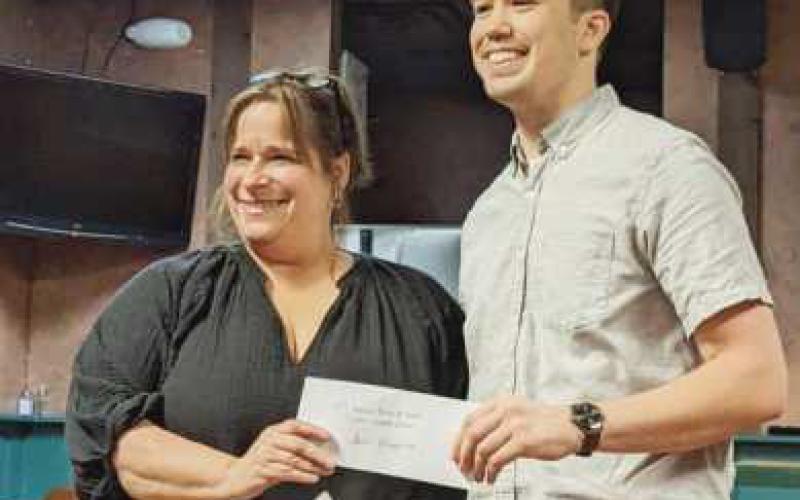 Above, Waterville Chamber Director Jackie Lehman, left, presents a check to Jason Chappuies, winner of the T-shirt design contest for the 50th annual Roche de Boeuf festival. The T-shirts will be for sale at the festival.