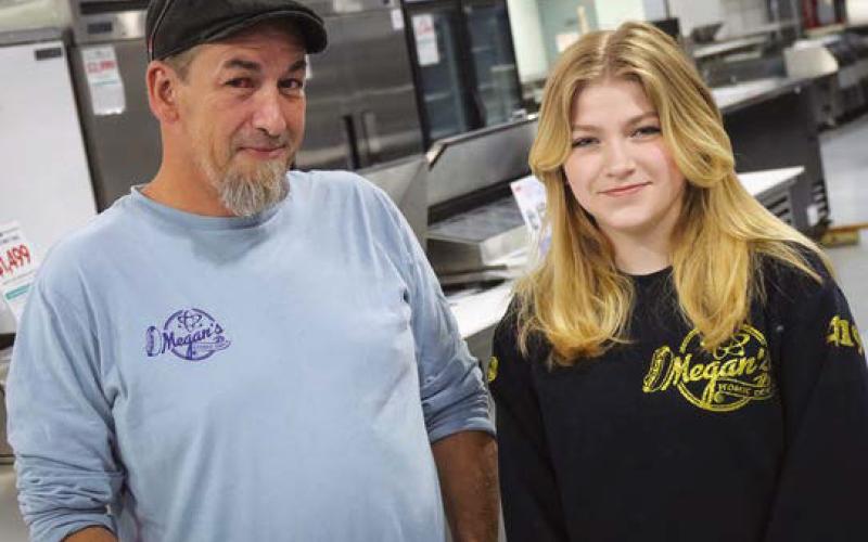 Shawn Biggs and his daughter Megan Wilburn-Biggs sport Megan’s Atomic Dogs merchandise, Megan’s self-owned and self-managed hot dog business.