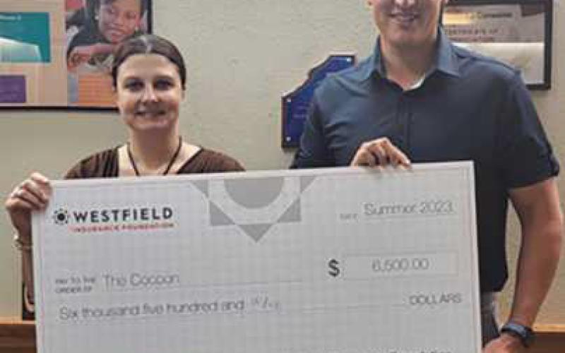 Kathy Mull, left, executive director of the Cocoon, with First Insurance Group agent, Matt Karaffa, right.
