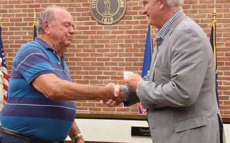 Mayor Mackin (right) shakes hands with Bob Warnimont (left) in recognition of his service to the Fort Meigs Cemetery Board.