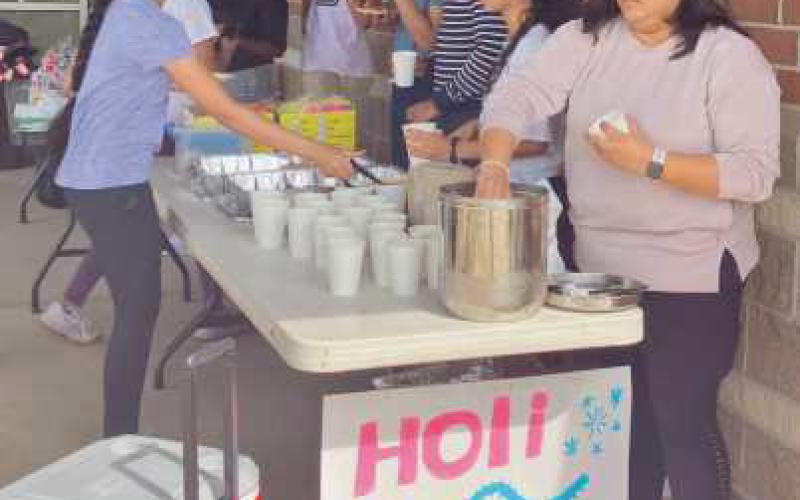 Members of the Indian Heritage Club assist visitors with tie-dye and serve refreshments.