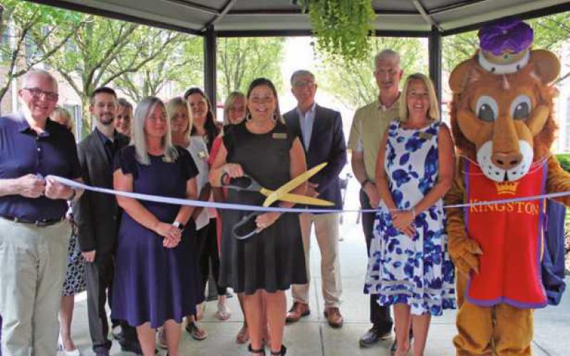 Karen Burnard, executive director, cuts the ribbon in celebration of Kingston’s 25th anniversary. She is joined by Kingston’s mascot, staff members and Perrysburg officials.