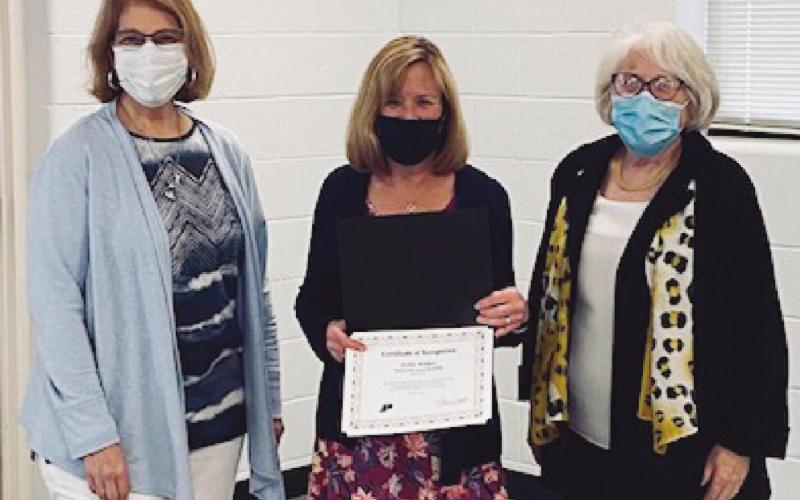 School board members Sue Larimer, left, and Gretchen Downs, right, with Debbie Reddic, who was honored as the district’s Shining Star for spring 2021.