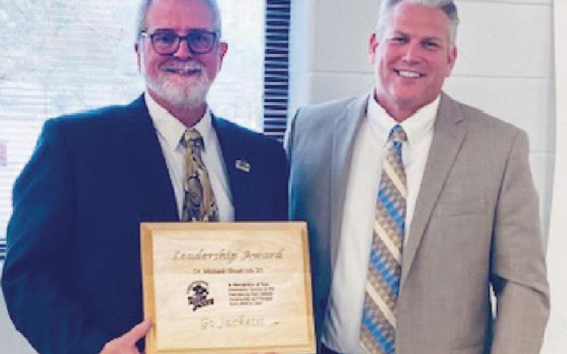 Superintendent Tom Hosler presents an award to PHS Principal Dr. Mike Short, who retires this summer.