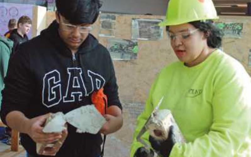 Samarth Dubey learns brick laying from Kieara Smith of Northwood, who is enrolled in masonry at Penta.