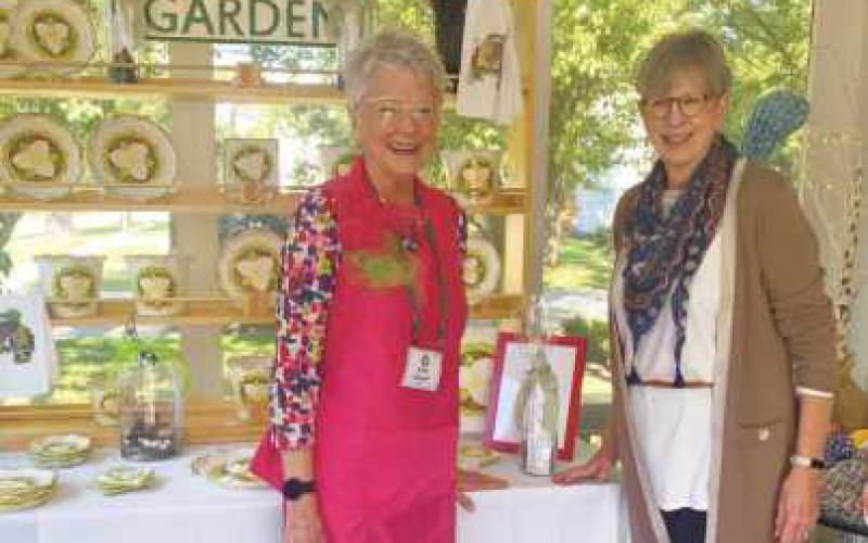 Country Garden Club members Kathy Attwood, at left, and Colleen McGoldrick in front of the club booth at the 2022 trunk show. Ms. McGoldrick is a co-chair of the upcoming show.