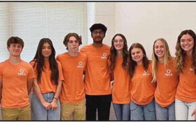 Board President Eric Benington congratulates some of the Perrysburg High School DECA students who qualified for state and international competitions.