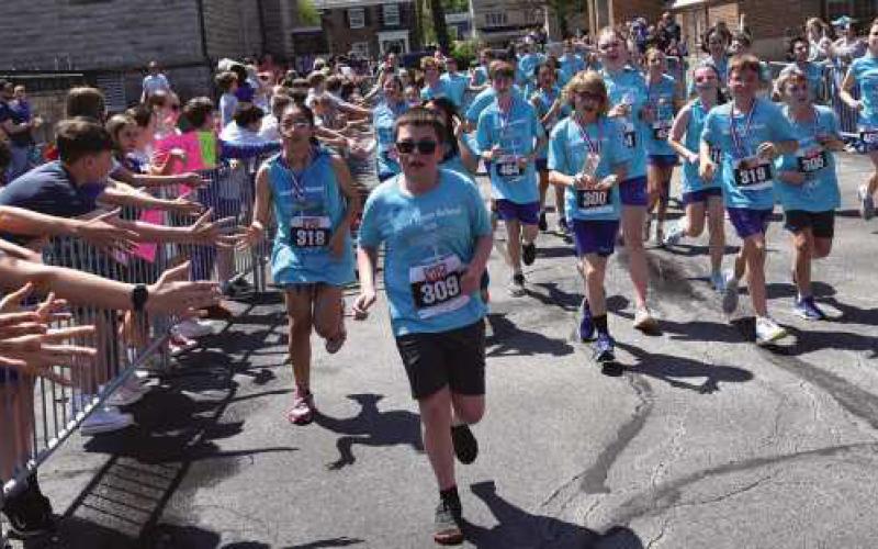 Saint Rose seventh and eighth graders run the 5k while classmates cheer them on.