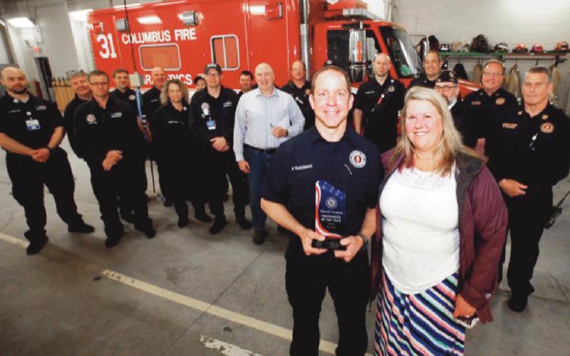 Holding his award is Firefighter Warnimont with his wife Terri at the crew at Station 31.