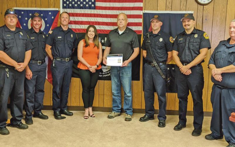 Elizabeth Lewis, center, presents Fire Chief Tom Brice with the AHA award.