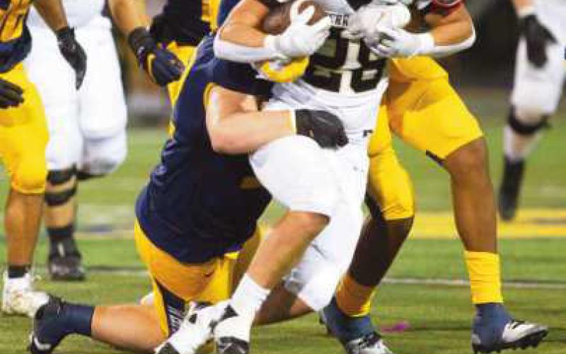 Runningback Nick Oros drags several Panthers with him as he surges forward for yardage.