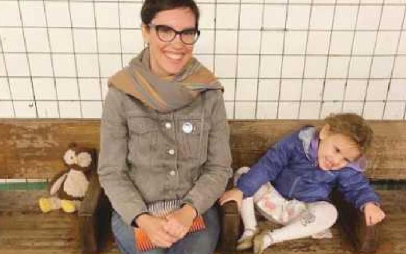 Amy Ballmer waits for a subway with her daughter, Lola.
