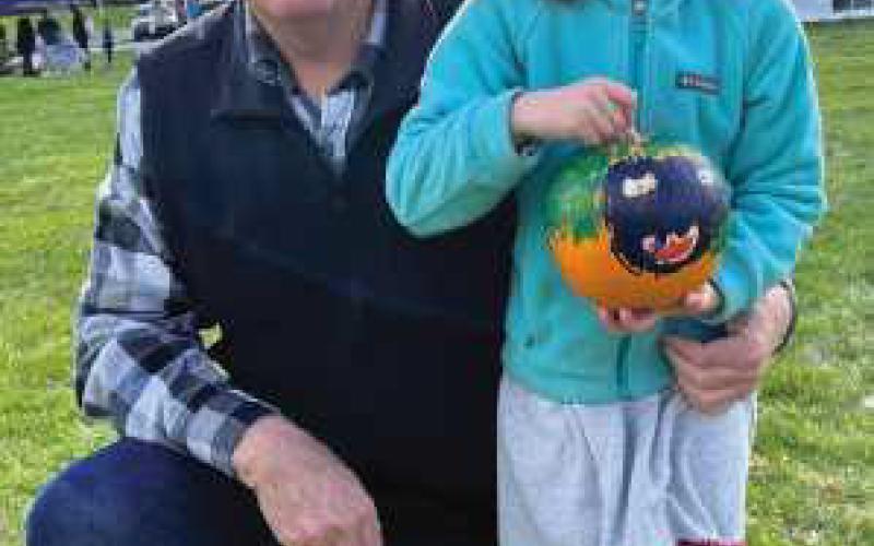 Lena Coulson, pictured with her grandfather and Perrysburg Rotarian Mark Weber, displays her painted pumpkin from last year’s event.