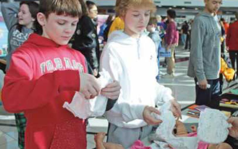 Will Schafer, left, and Caden Mohon practice changing a diaper at the early childhood exhibit.