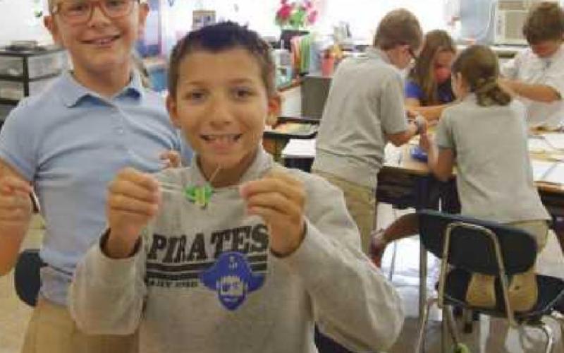St. Rose fourth-graders Gracie Borgelt and Max Campbell show off their science lab work from the first week of the school year. It focused on the proper lab procedures, teamwork and problem-solving skills. Groups of students had to get Fred, a gummy worm, out of its capsized boat and into a gummy lifesaver without touching the worm with their hands.