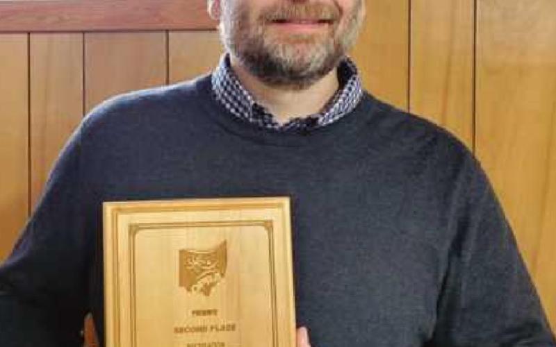 Chris Smalley, park director, displays an award plaque the park district received at the Ohio Parks and Recreation Association conference for its Masked Hero Geochase program.