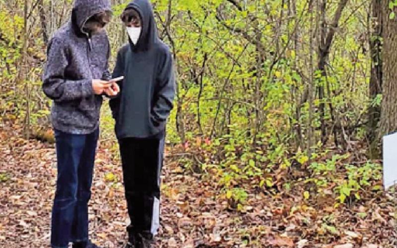 Participants find clues at signs and use their cell phones to solve the nature-based puzzles.