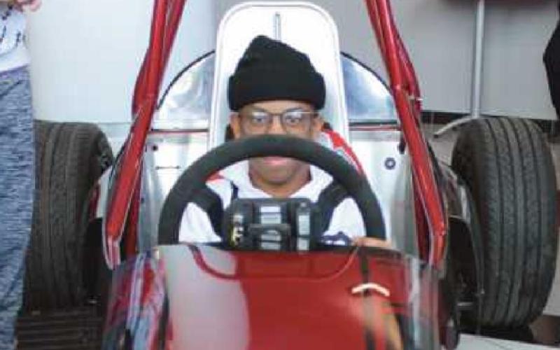 Alexander Denkins sits in the race car constructed by automotive students.