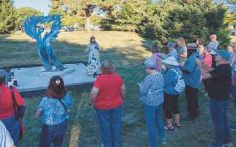 At top, “Wind of Words” by Toledo artist Robert “Bob” Garcia is part of the current Perrysburg Sculpture Walk at Woodlands Park. Below, curator-led tours of the exhibit are available.