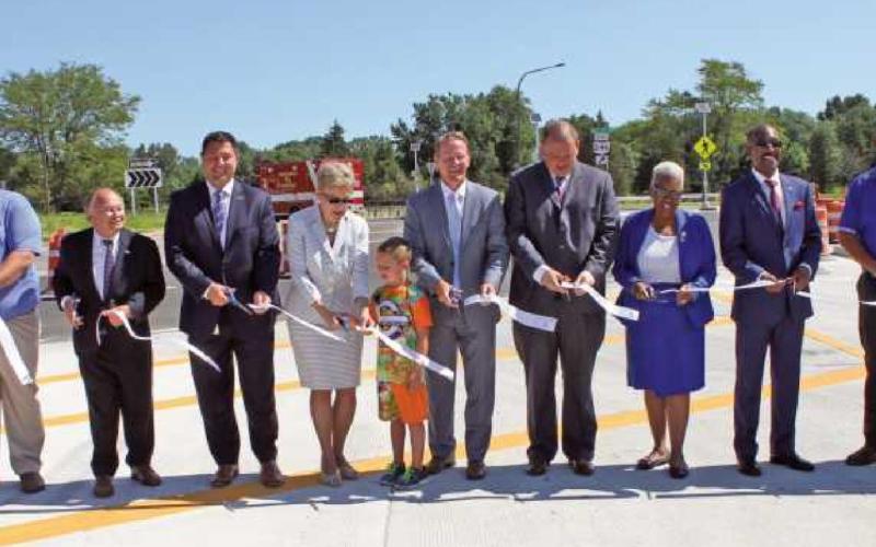 Ohio Lt. Governor Jon Husted and U.S. Congresswoman Marcy Kaptur, center, are flanked by public officials cutting the ribbon to officially open the I-475/Dorr Street interchange.