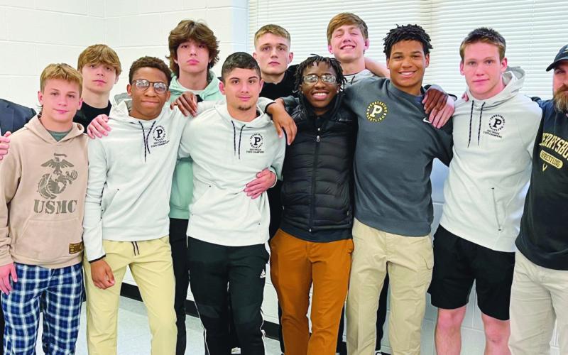 Board President Eric Benington congratulates the PHS wrestlers who qualified for state competition.