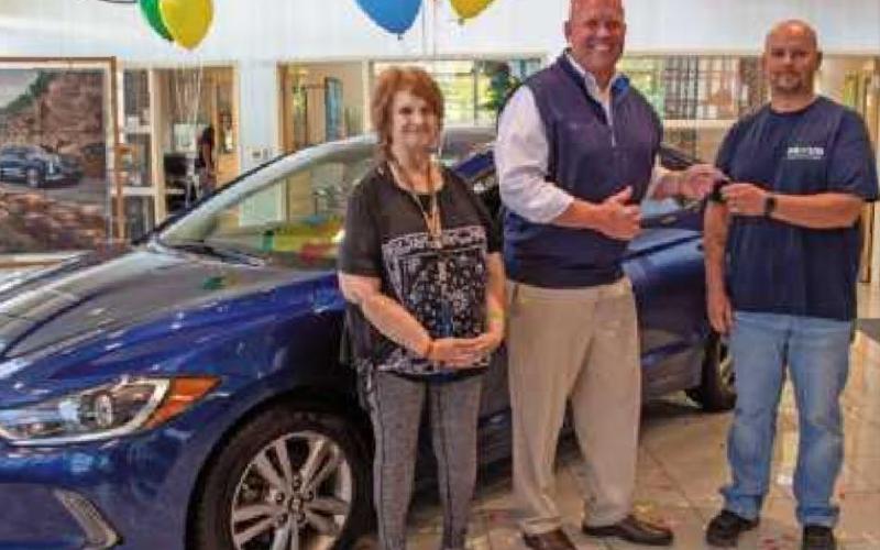 Steve Taylor, center, owner of Taylor Hyundai, hands the vehicleʼs keys to winner Tim Betts. At left is Pamela Betts.