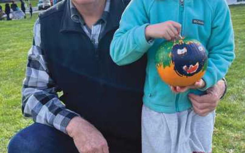 Lena Coulson proudly displays her painted pumpkin with grandfather and Perrysburg Rotarian Mark Weber.
