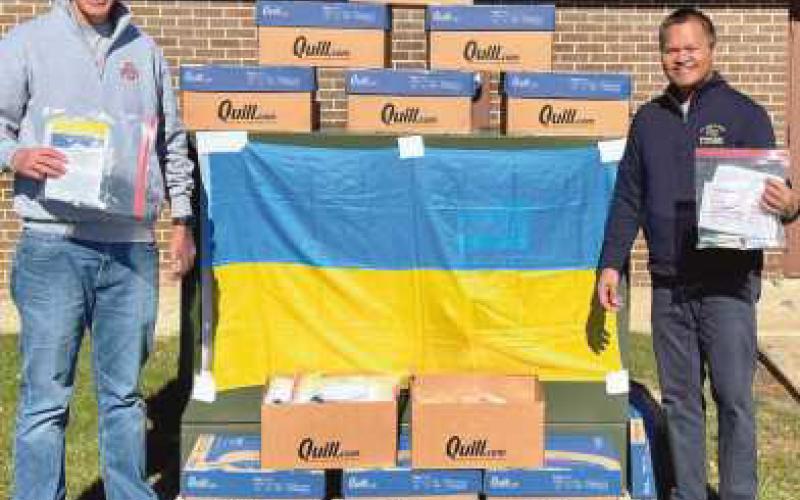 Dr. Richard Paat will take the kits on a mission trip with medical students and his non-profit SCORE medical team. Above left: St. Rose students package the supplies. Above right: Dr. Bryon Borgelt, principal of St. Rose School, presents the kits to Dr. Paat.