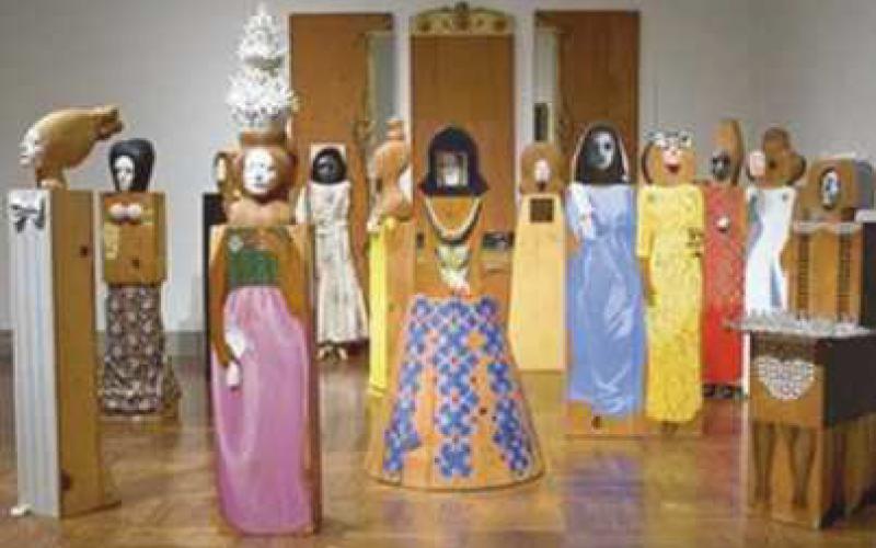 The exhibit includes “The Party,” an assemblage of 15 freestanding, life-size figures and three wall panels, with painted wood and carved wood, mirrors, plastic, television set, clothes, shoes, glasses and other accessories.