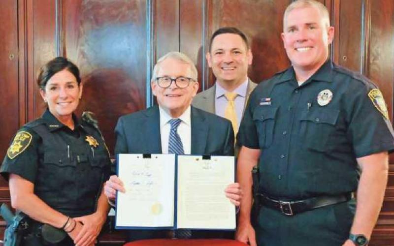 State Representative Haraz Ghanbari and Ohio Governor Mike DeWine are joined by Lake Township Police Department Officer Kelly Clark, left, and Perrysburg Township Police Detective Chris Klewer for the signing of House Bill 206 on June 24.