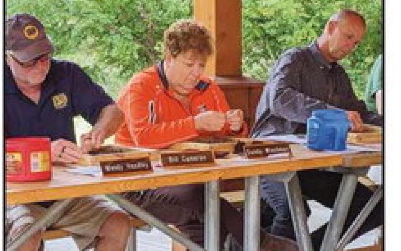 From left, park Commissioners Mr. Cameron, Ms. Wiechman and Tom Myers use a sifter to collect native plant seeds.